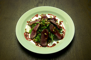 Meat with salad served on the white round  plate