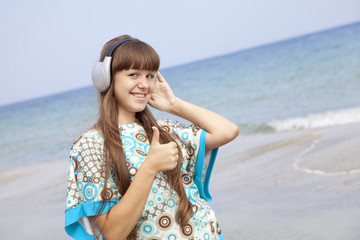 Fototapeta na wymiar Young brunet girl with headphone on the beach.