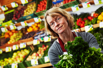 female sales assistant in front of fruit and veg stall 06