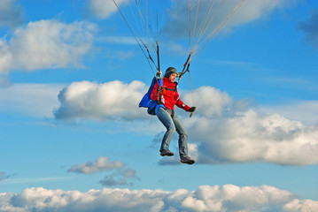 The young girl parachutist in cloudy sky