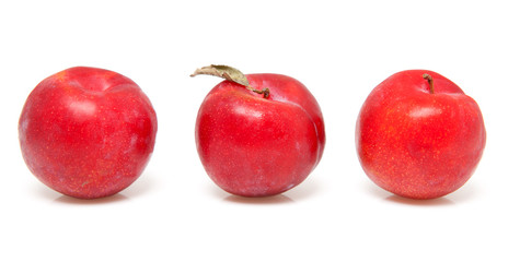 three red plums over white background