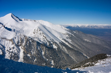 Fototapeta na wymiar Panorama of winter mountains. Alpine ski resort Bansko, Bulgaria