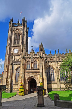 Manchester Cathedral against blue sky and fluffy white clouds in Manchester Greater Manchester U.K.