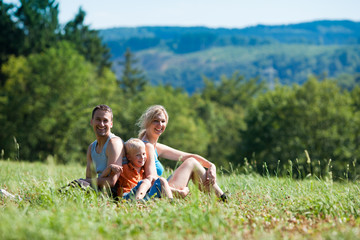 Familie in Sportkleidung auf Wiese