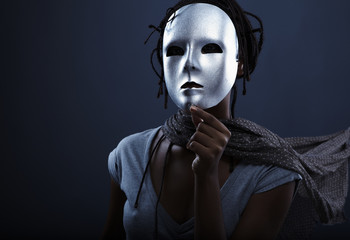 gloomy woman in silver mask posing on a black background.