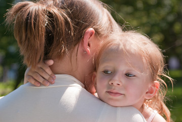 little girl hugging her mother's neck