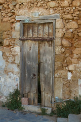 Fototapeta na wymiar Old worn-out door in disrepaired wall.