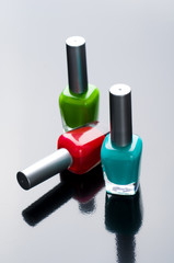 Nail polish bottles on glossy background