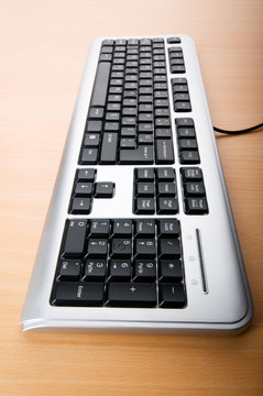 Computer keyboard on the wooden polished table