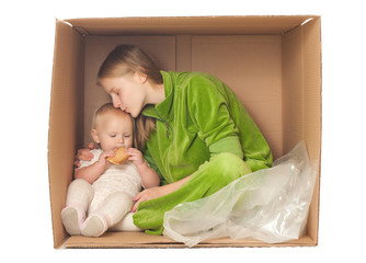 cheerful mother sit in box with baby eating cookie