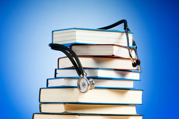 Books and stethoscope against the gradient background