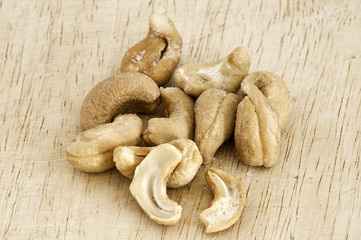 Heap of a roasted cashew nuts on an old wooden table.