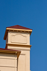 Yellow Stucco Tower with Red Tile Roof on Blue Sky