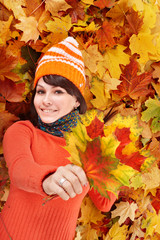 Young woman in autumn orange leaves.