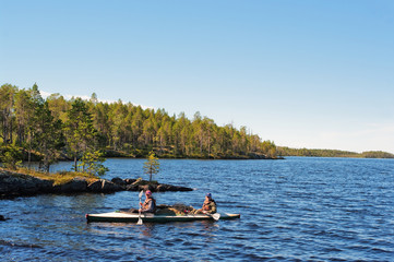 Fototapeta na wymiar Tourists float in canoe