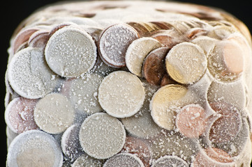 Shiny euro coins frozen in ice