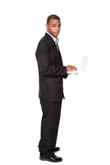 African American businessman standing while using notebook compu