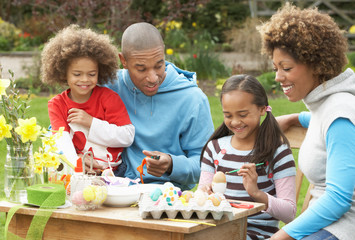 Family Painting Easter Eggs In Gardens