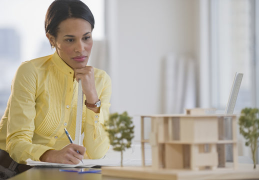 Mixed race architect studying building model