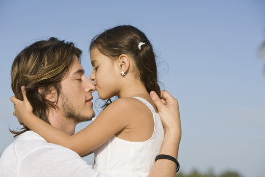 Hispanic girl kissing father