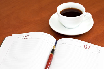 Coffee cup, notebook and pen