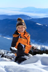 Fototapeta na wymiar Happy boy on snowy mountain