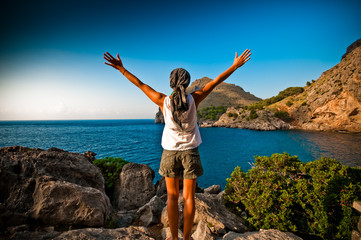 women with arms in the air facing the sea  in black and white