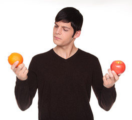 Caucasian man comparing apple to orange