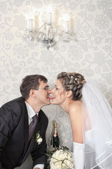 Groom kissing bride with a long tongue in stylish indoors