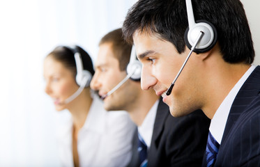 Three support phone operators at workplace