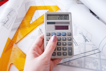 Calculator and drafting tools on architectural desk