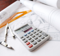 Calculator and drafting tools on architectural desk