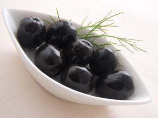 Black olives in the white bowl. Macro