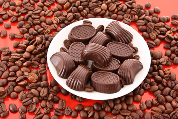 Chocolate and coffee beans on red background