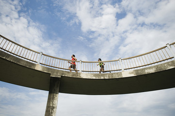 Couple running on bridge