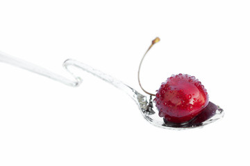 cherries lying in the spoon isolated on white