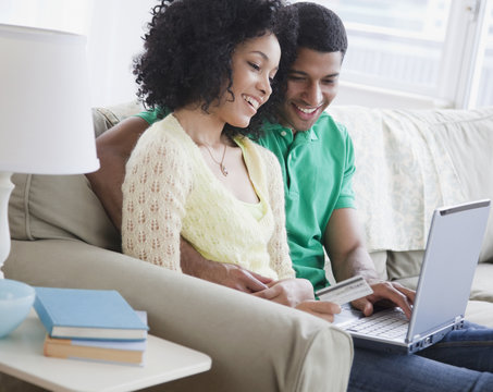 Couple shopping online in living room