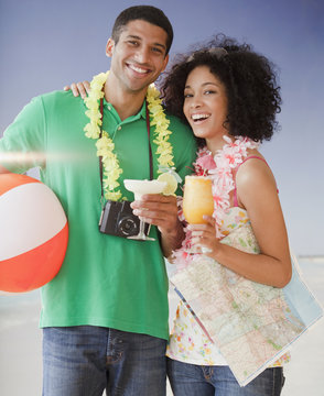 Couple on beach with tropical drinks