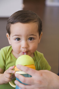 Hispanic baby boy drinking from cup