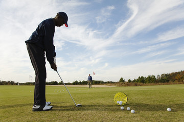 African boy practicing putting on golf course