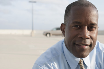 African businessman standing in parking lot