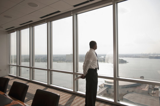 African American businessman looking out office window