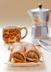 Pancakes with meat filling on the wooden table