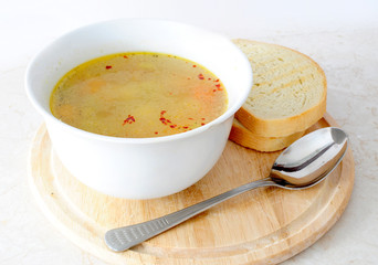 Vegetable / chicken soup with bread and spoon