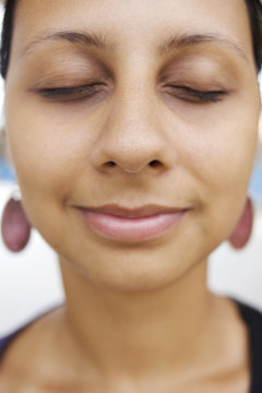 Smiling mixed race woman meditating