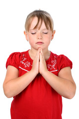 Fototapeta premium Small girl with clasped hands and eyes closed praying isolated