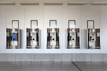 public phones in hall with white walls and granite floor