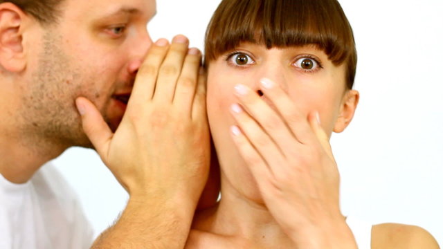 Man telling a secret to a surpirsed girl