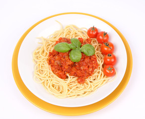 Spaghetti Bolognese on a plate with basil and cherry tomatoes
