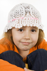 Portrait of the small shy girl in a cap.